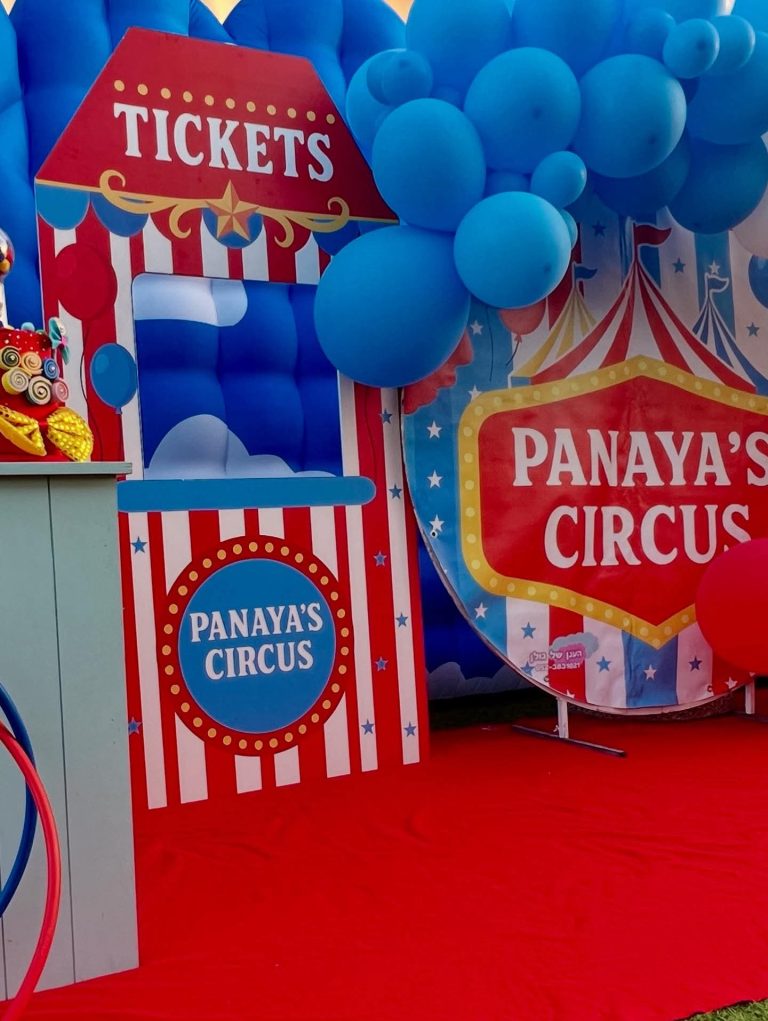 עמדת כרטיסים מעוטרת בבלונים בכניסה ל-Panaya's Circus