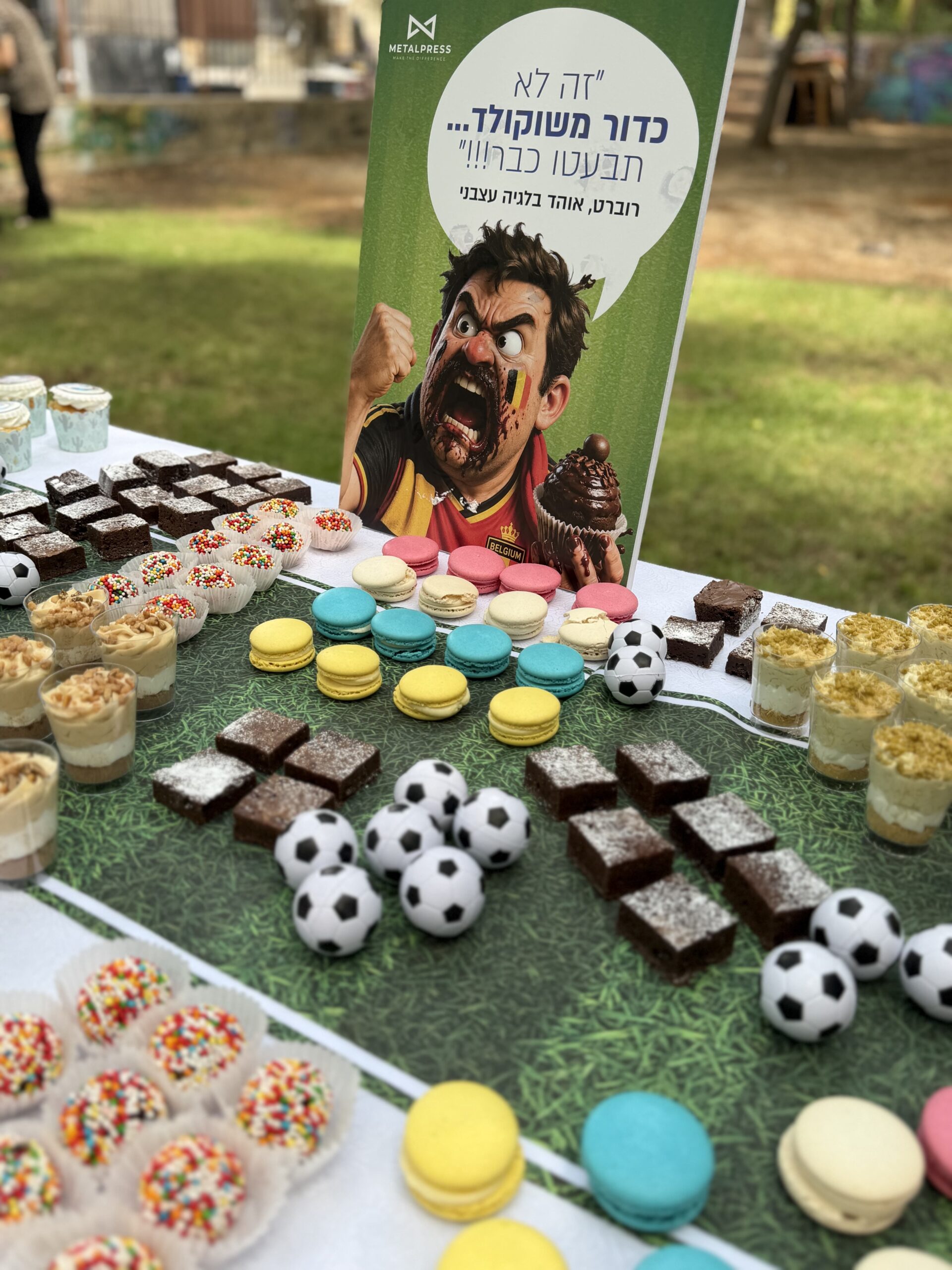 עמדת מתוקים בהשראת מונדיאל — מקרונים וקוביות שוקולד בעיצוב מגרש כדורגל