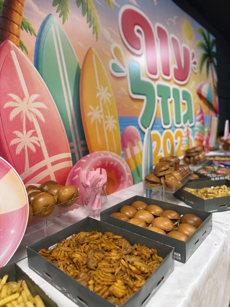 בופה עשיר עם המבורגרים ומטוגנים לצד קיר הצילום הממותג